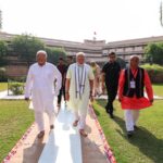 Prime Minister Narendra Modi walks along with Rashtriya Swayamsevak Sangh (RSS) Chief Mohan Bhagwat and others as he arrives to pay tribute at RSS