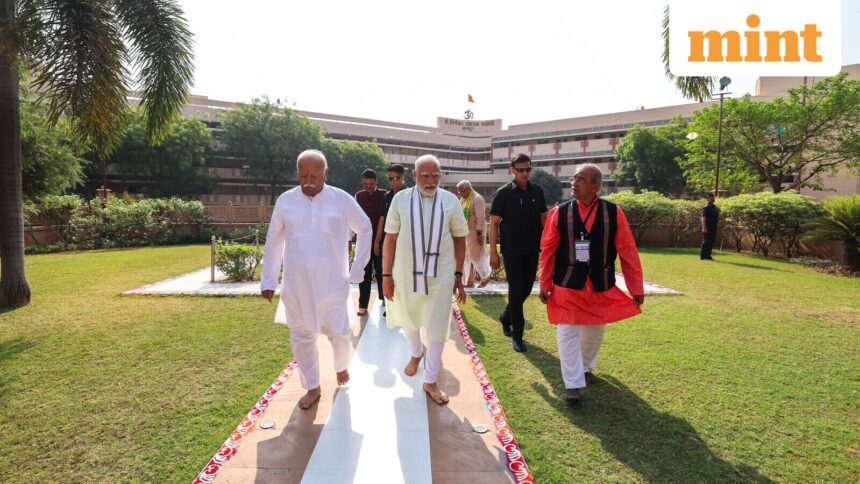 Prime Minister Narendra Modi walks along with Rashtriya Swayamsevak Sangh (RSS) Chief Mohan Bhagwat and others as he arrives to pay tribute at RSS