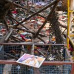 A portrait of actor and Tamilaga Vetri Kazhagam (TVK) chief Vijay lies on a metal fencing at an area partially covered in footwear and other belongings of attendees, after a stampede broke out in the actor-politician