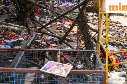 A portrait of actor and Tamilaga Vetri Kazhagam (TVK) chief Vijay lies on a metal fencing at an area partially covered in footwear and other belongings of attendees, after a stampede broke out in the actor-politician
