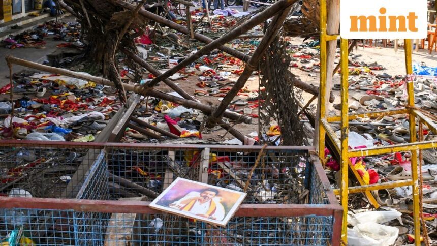 A portrait of actor and Tamilaga Vetri Kazhagam (TVK) chief Vijay lies on a metal fencing at an area partially covered in footwear and other belongings of attendees, after a stampede broke out in the actor-politician