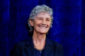 President-elect Catherine Connolly reacts as she stands on a stage at Dublin Castle, on the day of the announcement of the results of the Irish presidential election in Dublin, Ireland, October 25, 2025.