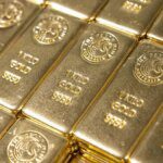 Gold slips as Fed rate caution boosts dollar, set for 3rd monthly rise