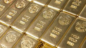 Gold slips as Fed rate caution boosts dollar, set for 3rd monthly rise