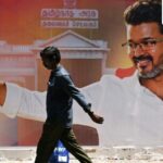 A man walks past a poster praising the victory of actor and Tamilaga Vettri Kazhagam (TVK) party president C. Joseph Vijay in Chennai on May 7, 2026 after the Tamil Nadu assembly election results were announced on May 4 (AFP)